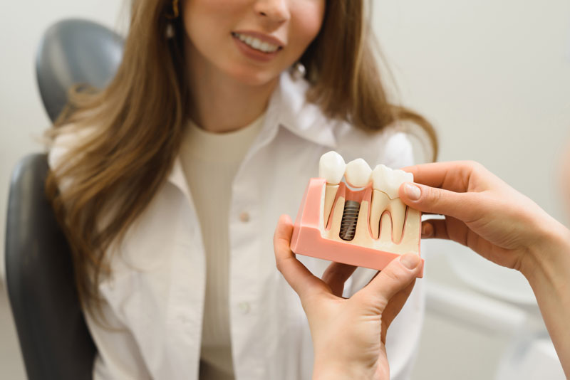 Dental Patient Getting Shown A Dental Implant Model During Her Consultation in St. Charles, IL