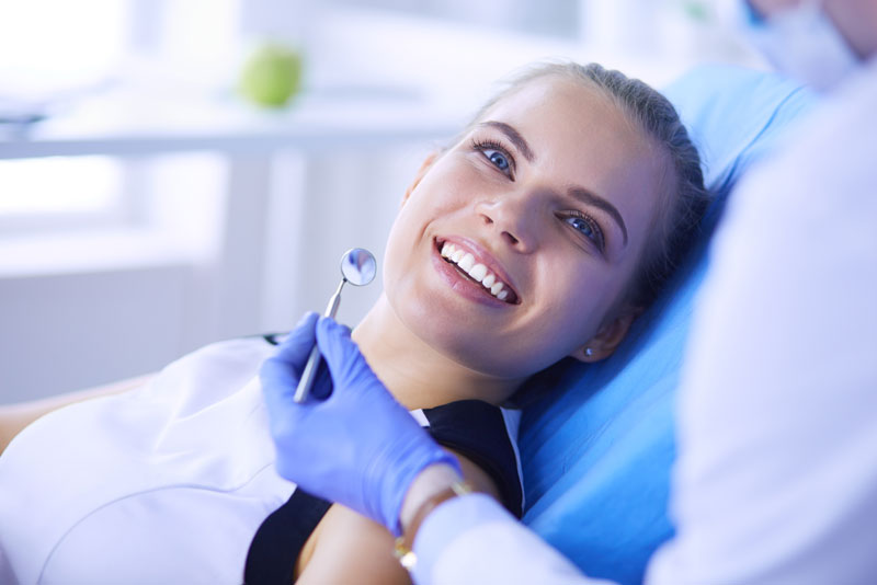 a new dental patient smiling during a dental examination.