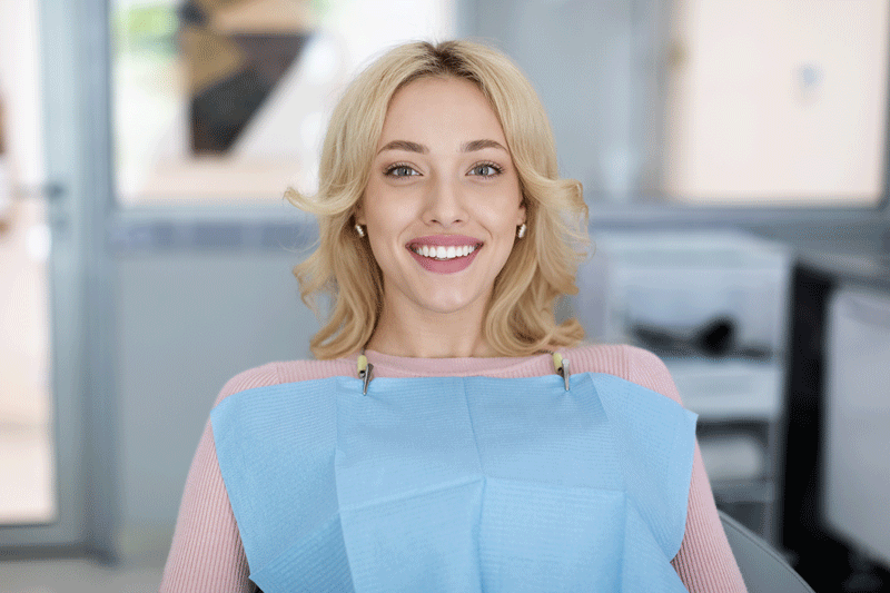 Young women in a dental chair smiling.