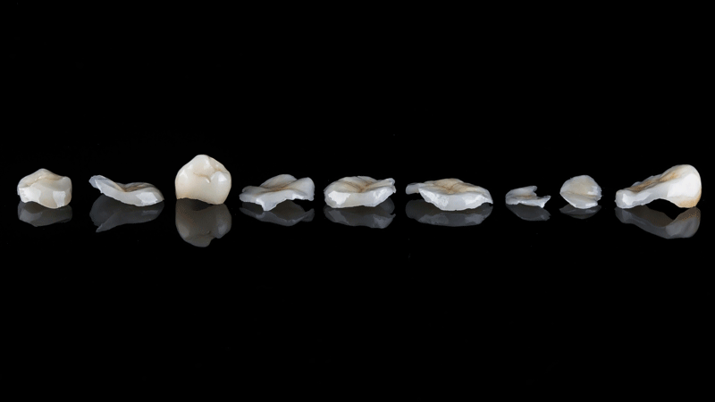 dental crowns laying on black reflective glass