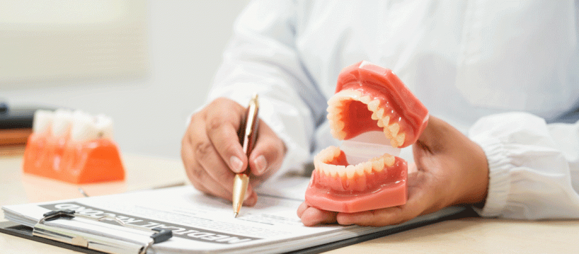 A doctor sits at a table in a hospital, discussing dental issues with a new dental patient. sitting in dental office.